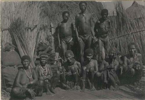 Group of men in front of a hut