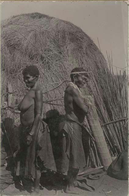 Woman and man in front of a hut