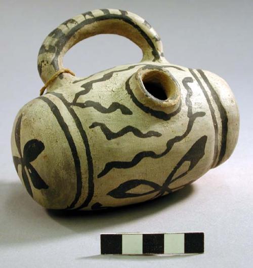 Clay pottery canteen. Bowl-shaped with loop handle. Black on white.