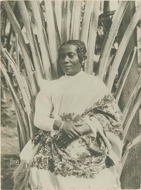 Woman sitting in front of plant