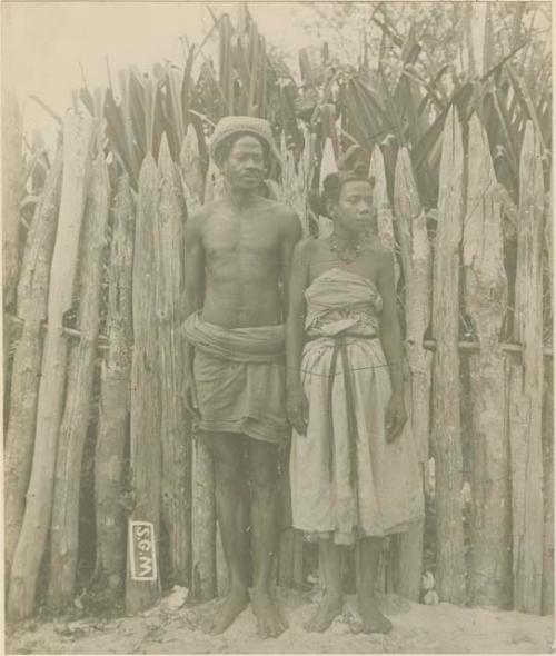 Man and woman standing in front of fence