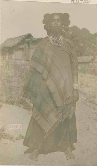 Woman standing, with buildings in background