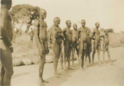 Group of men standing next to bundles of antelope nets