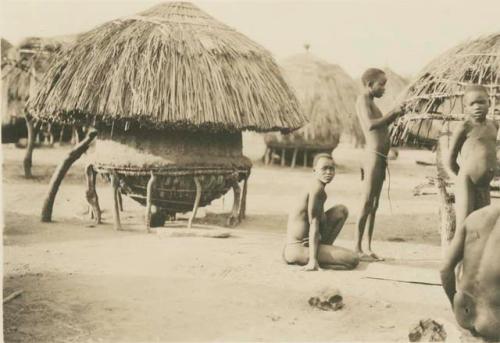 Women and boys next to a granary