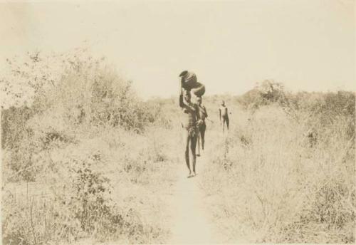 Women walking and carrying pots on their heads