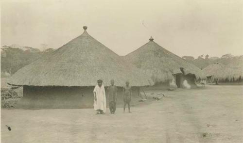King Musi standing in front of Babutu hut