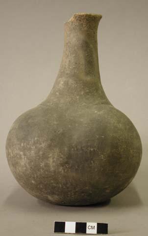 Ceramic complete vessel, long neck, four lobes, groove around shoulder, chipped