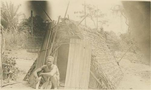 Man sitting in front of hut