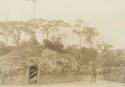 Man standing between two huts