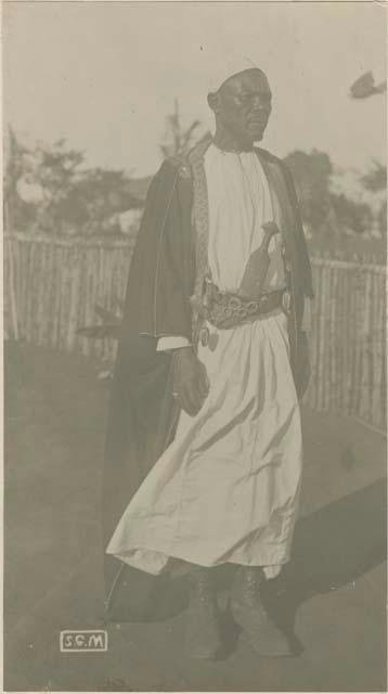 Man standing in front of a fence