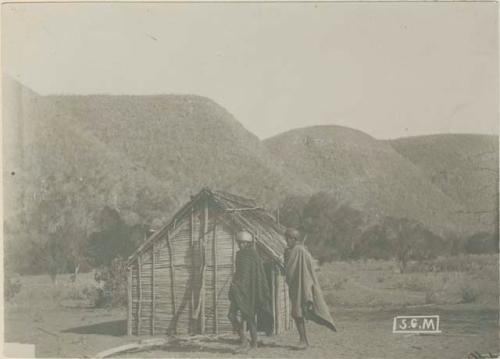 Two men in front of a house