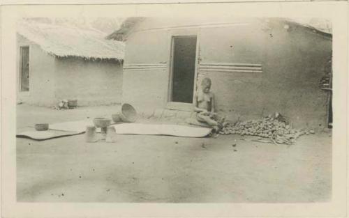 Woman working in front of hut