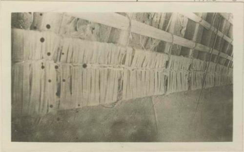 Binding leaves around laths to make roof mats