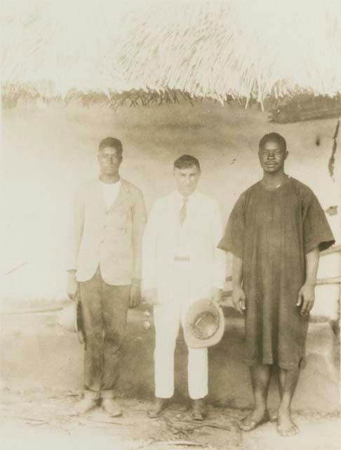 Three men standing in front of structure