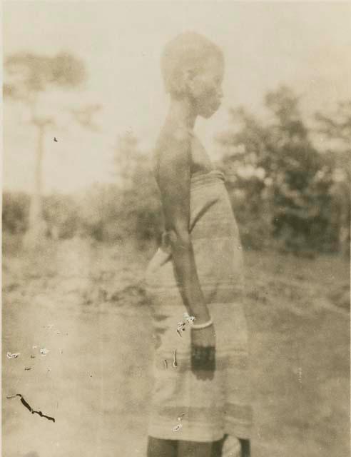 Woman standing, with trees in background