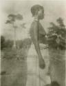 Woman standing, with trees in background