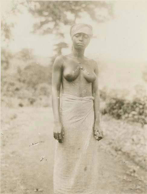 Woman standing, with tree in background