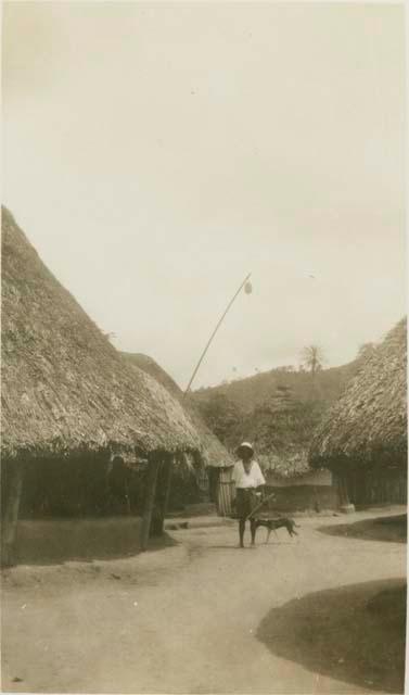 Man and dog standing next to huts