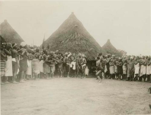 Large group of people in front of huts