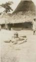 Rock and stick structure in front of a hut