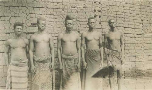 Five men standing in front of a building, front view