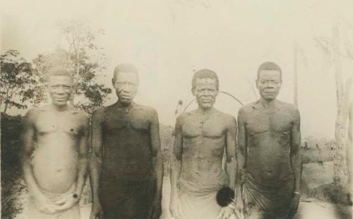 Four men standing, front view