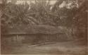 People sitting in front of a hut