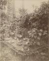 Grave with metal two large glass bottles, ceramic chicken and other objects