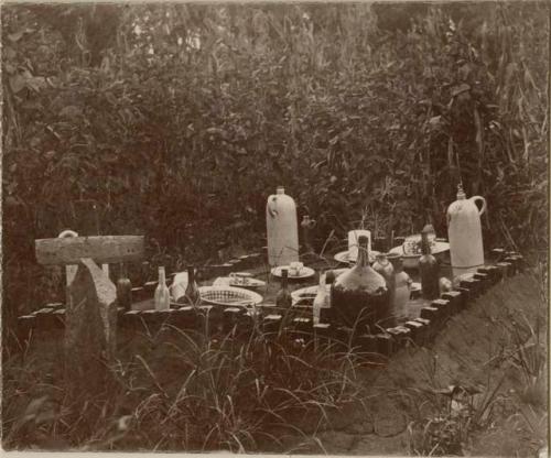 Grave with bottles, jugs and dishes