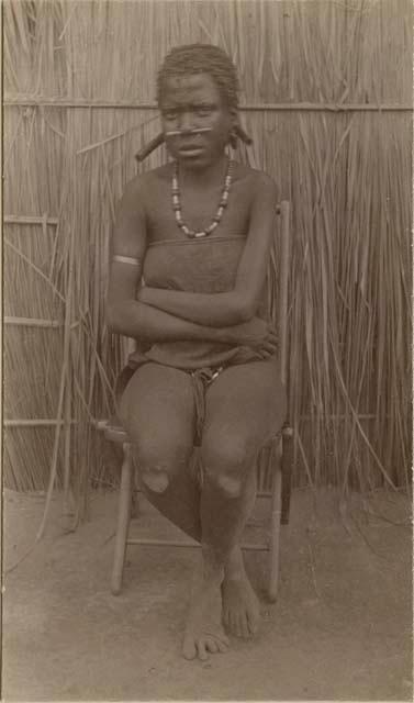 Girl sitting in front of a hut