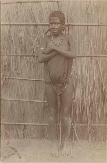 Girl standing in front of a hut