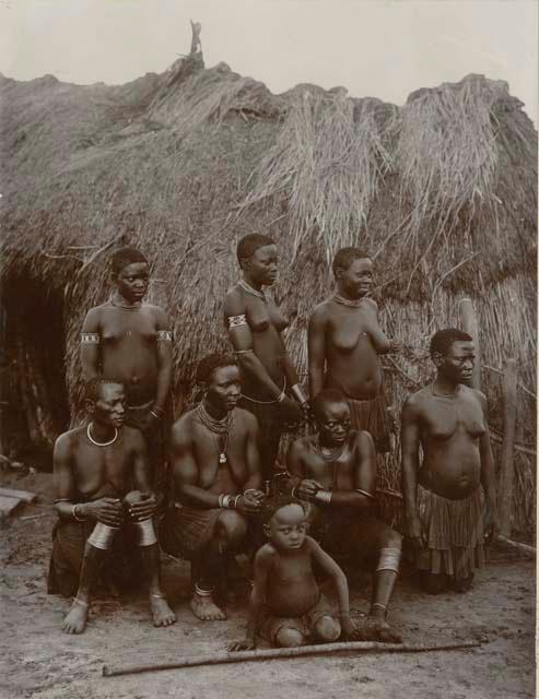 Group posed in front of a hut