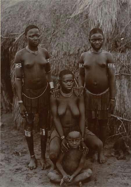 Group posed in front of a hut