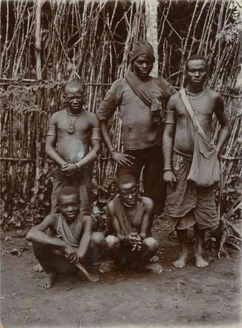 Group of men posed in front of a fence