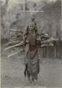 Woman carrying child and load of firewood