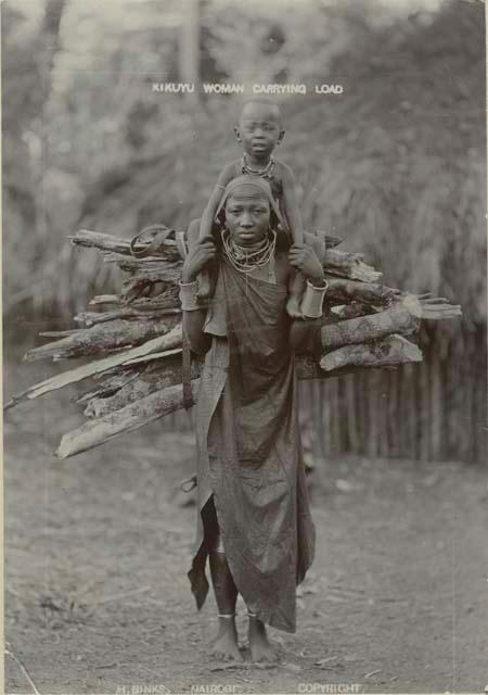 Woman carrying child and load of firewood