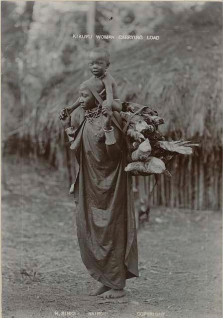 Woman carrying child and load of firewood