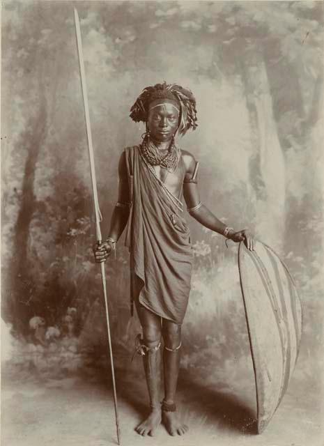 Studio portrait of a man standing and holding a spear and shield