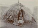 Group of four in front of a hut