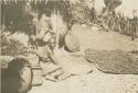 Women drying grain in courtyard of house