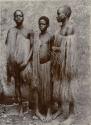 Three men standing in front of a wall