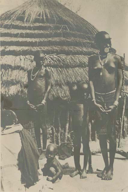 Family standing in front of a hut