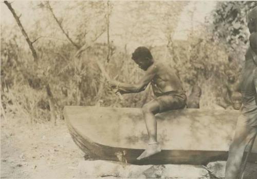 Man working on a dugout canoe