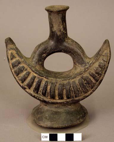 Ceramic bottle, stirrup spout, crescent shaped body, incided, flat base