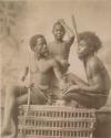 Posed studio portrait of three boys with hunting implements