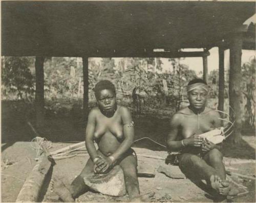 Women grinding peanuts and playing "harp"