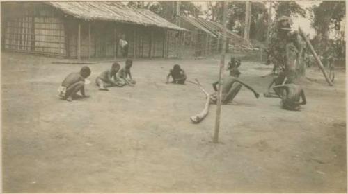 C'njik game, with hut in background