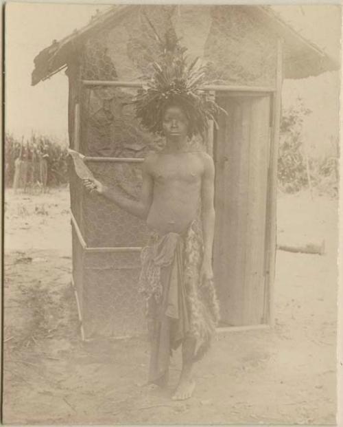 Man standing in front of a hut