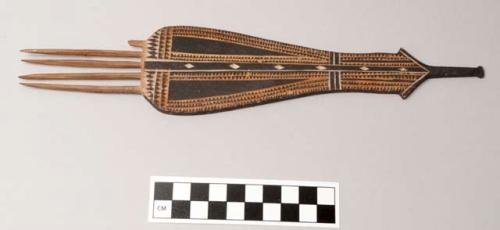 Comb with geometric carvings and black and white pigment