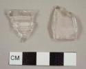 Colorless curved glass fragments, including one fluted tumbler fragment and one with molded ribbing on exterior